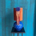 Lámpara de mesa azul y pantalla terracota textil.
