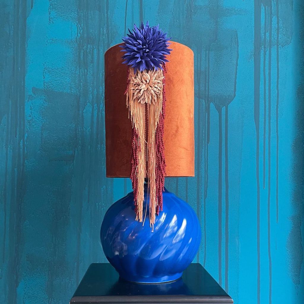 Lámpara de mesa azul y pantalla terracota textil.
