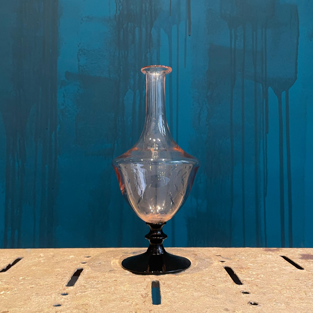 Jarrón Vintage vidrio rosa con base negra.