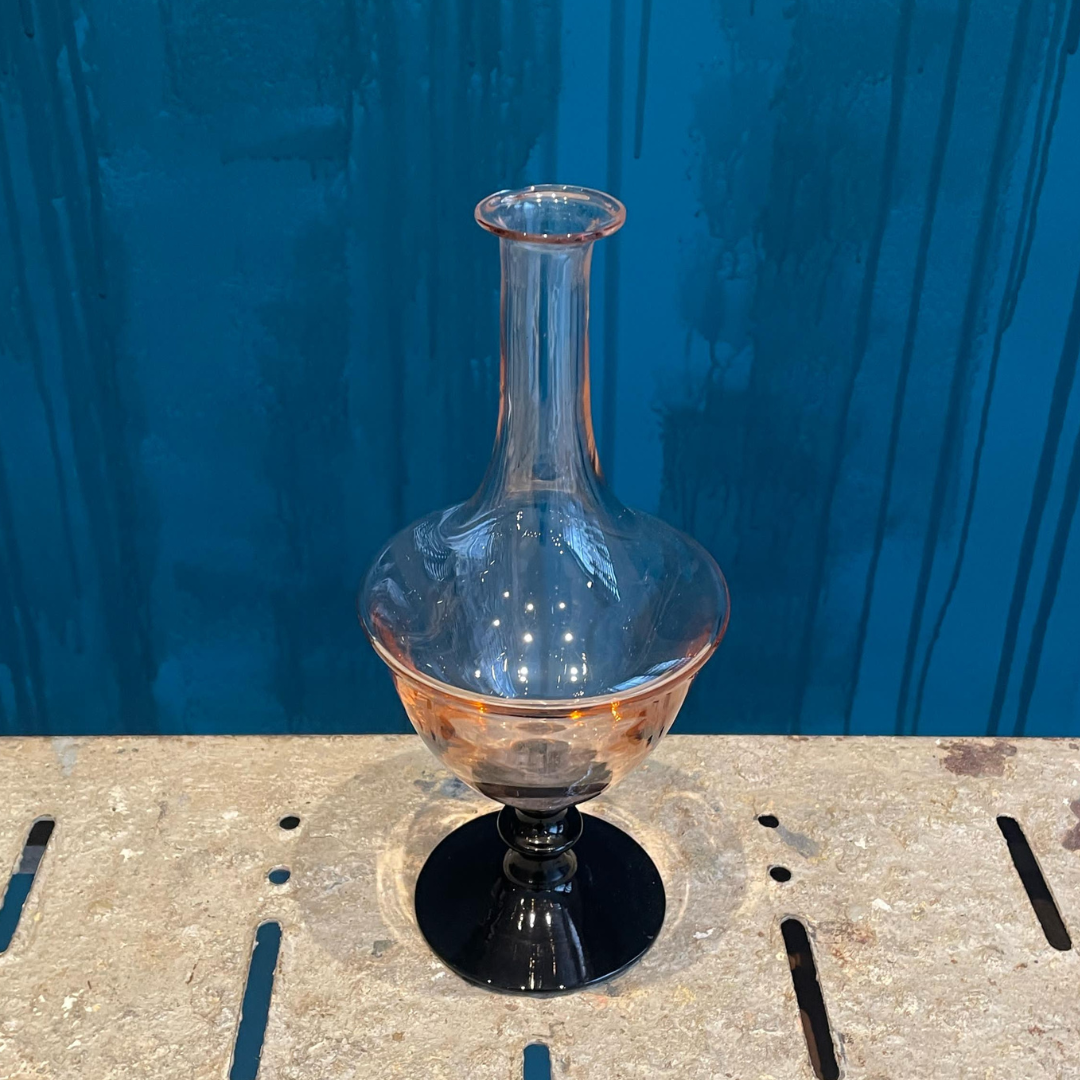 Jarrón Vintage vidrio rosa con base negra.