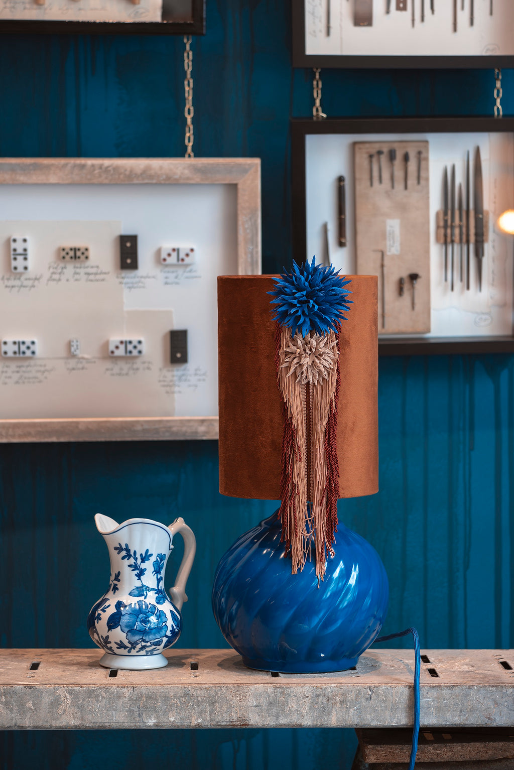 Lámpara de mesa azul y pantalla terracota textil.